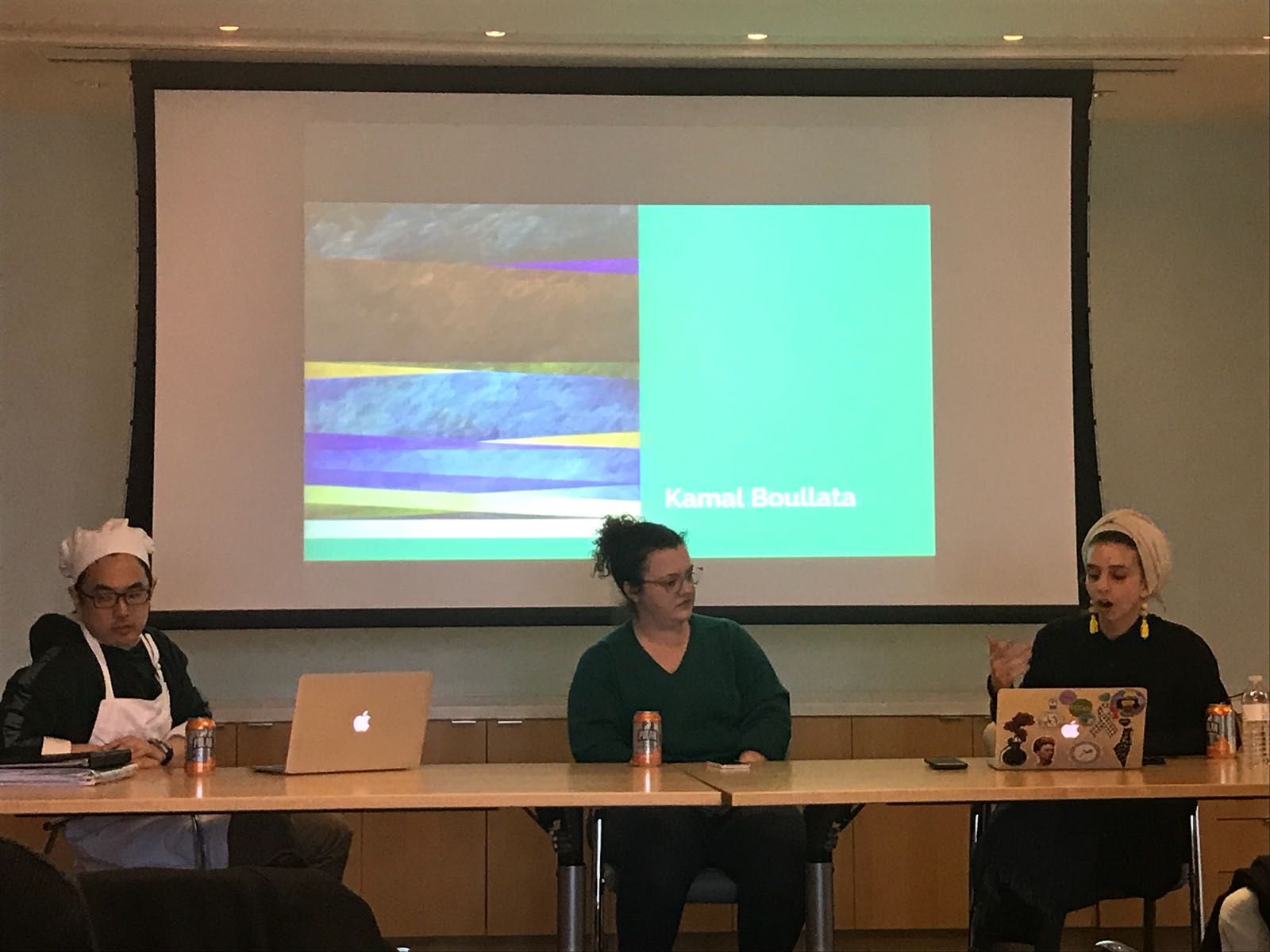 three students sit in front of screen on panel